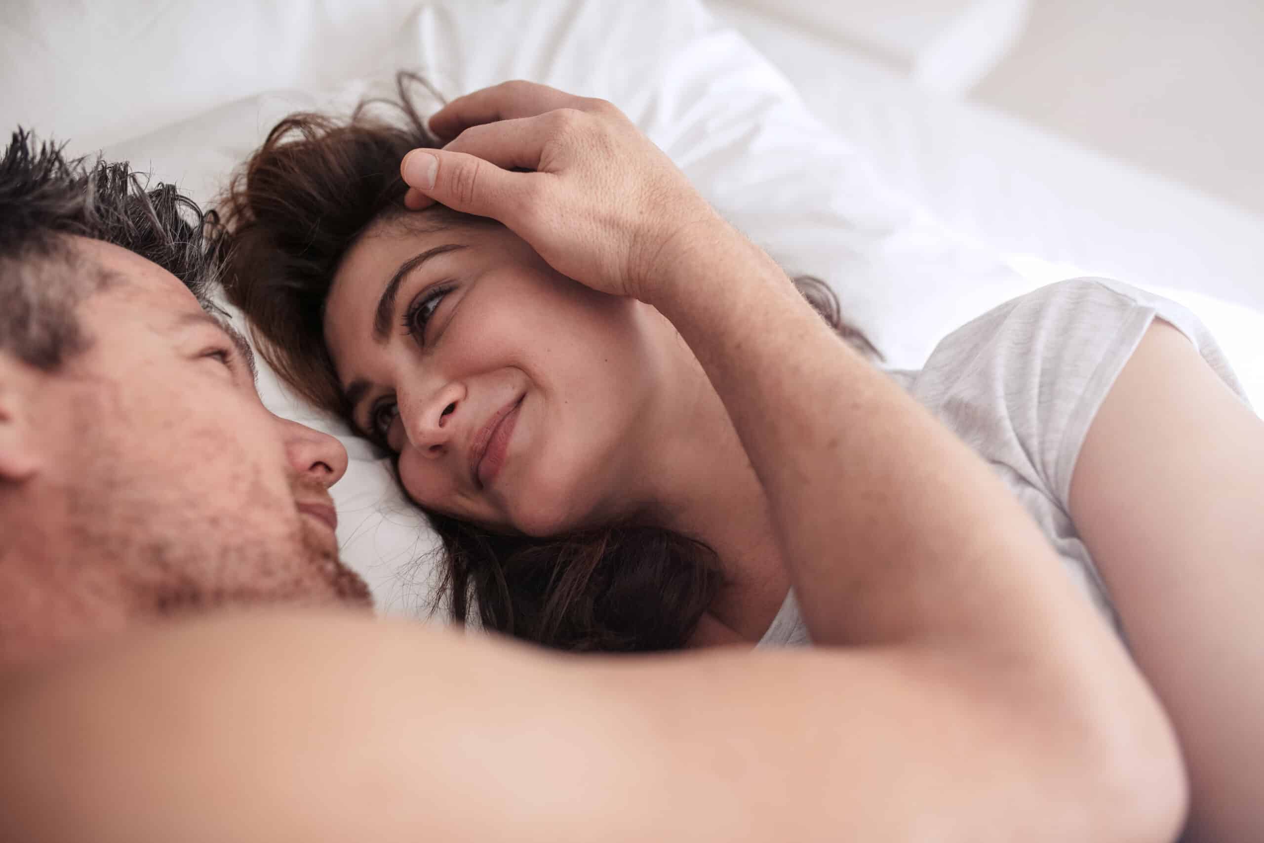 Romantic,Young,Couple,Lying,Together,On,Bed.,Man,And,Woman